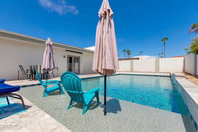 view of pool with french doors, a patio, and pool water feature