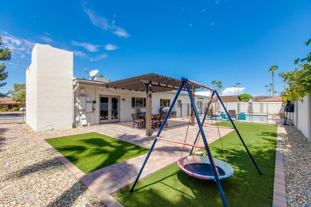 back of house featuring a playground, french doors, a patio, and a trampoline