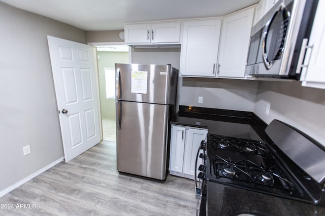 kitchen with white cabinets, stainless steel appliances, and light hardwood / wood-style floors