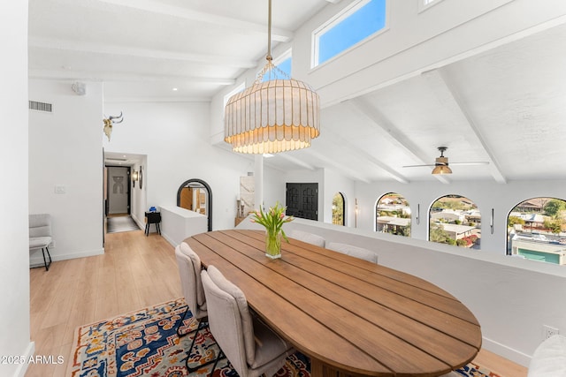 dining space featuring ceiling fan, beamed ceiling, and light hardwood / wood-style flooring