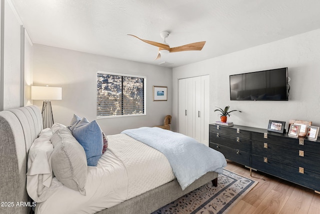 bedroom with ceiling fan, a closet, and light wood-type flooring