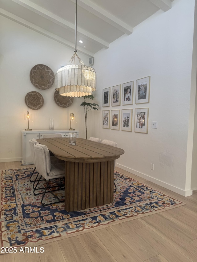 dining room featuring hardwood / wood-style flooring and beamed ceiling