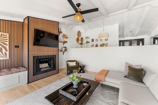 living room featuring ceiling fan, light hardwood / wood-style flooring, and lofted ceiling with beams