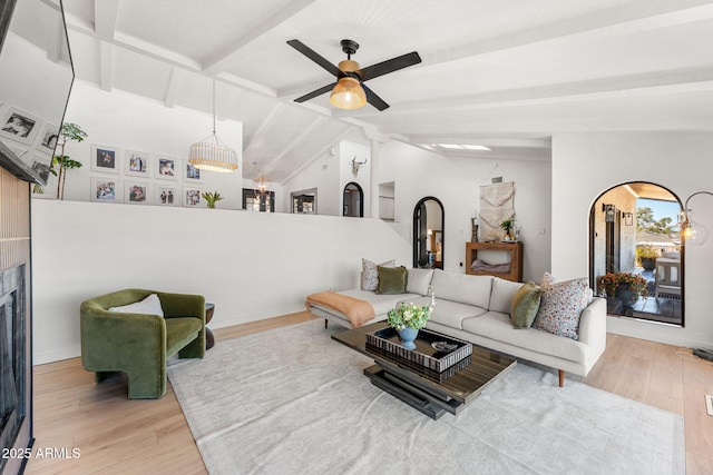 living room featuring ceiling fan, light hardwood / wood-style flooring, and lofted ceiling with beams