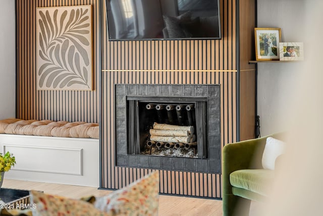 room details featuring wood-type flooring and a tiled fireplace