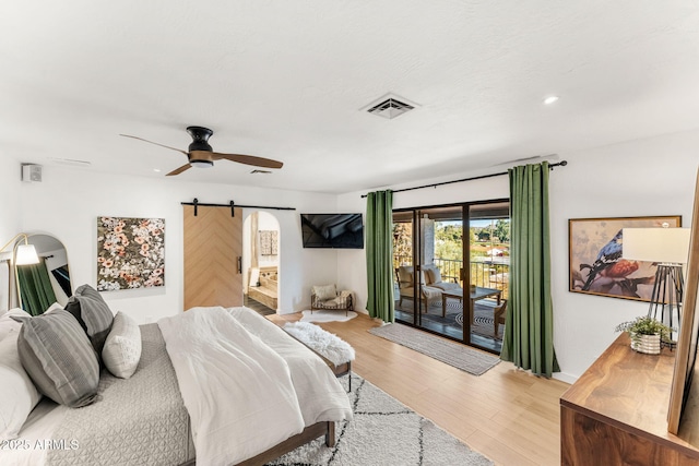 bedroom with ceiling fan, access to outside, a barn door, and light wood-type flooring