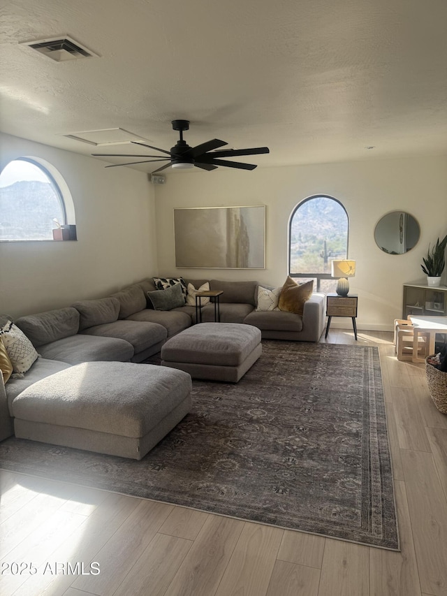 living room featuring light wood-type flooring and ceiling fan