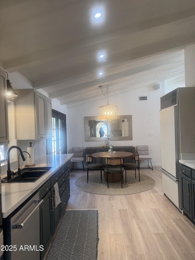 kitchen featuring sink, built in fridge, dishwasher, a chandelier, and lofted ceiling with beams