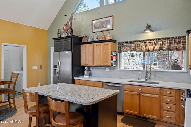 3123 S Indian Paint Ln, Pinetop, AZ 85935 - kitchen with appliances with stainless steel finishes, a sink, light wood-style floors, washer / clothes dryer, and high vaulted ceiling