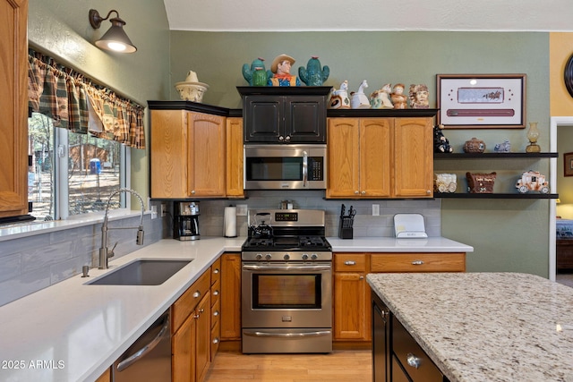 3123 S Indian Paint Ln, Pinetop, AZ 85935 - kitchen featuring appliances with stainless steel finishes, a sink, backsplash, light wood-style floors, and light stone counters