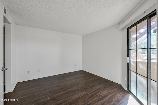 unfurnished room with a textured ceiling and dark hardwood / wood-style floors