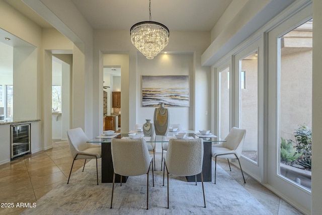 tiled dining area featuring beverage cooler and a chandelier