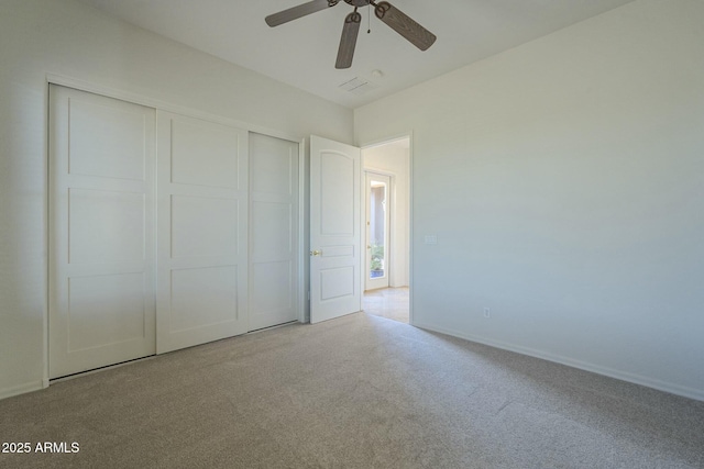 unfurnished bedroom featuring light carpet, a closet, and ceiling fan