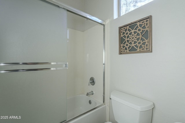 bathroom with bath / shower combo with glass door and toilet