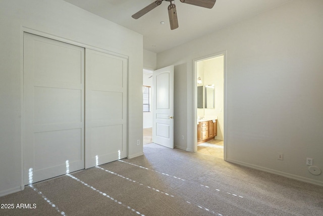 unfurnished bedroom featuring connected bathroom, a closet, and ceiling fan