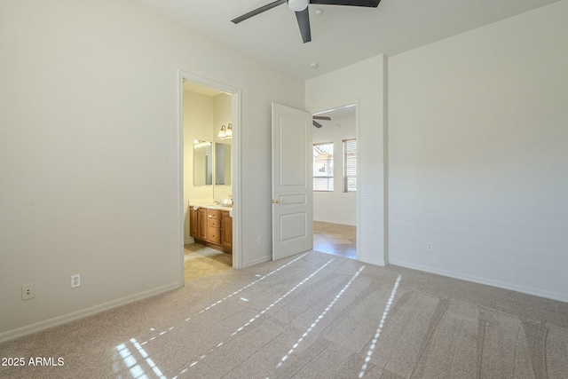 unfurnished bedroom featuring ceiling fan, connected bathroom, and light colored carpet