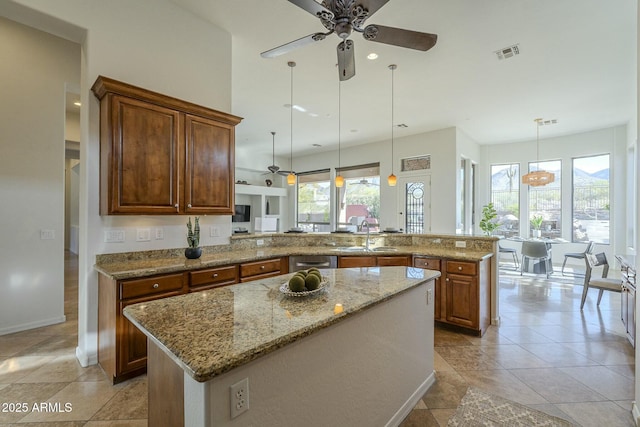 kitchen featuring sink, a center island, hanging light fixtures, stainless steel dishwasher, and kitchen peninsula