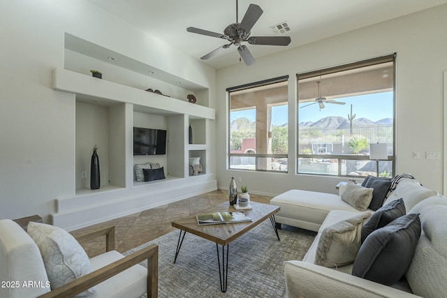 living room with light tile patterned flooring, built in features, and ceiling fan