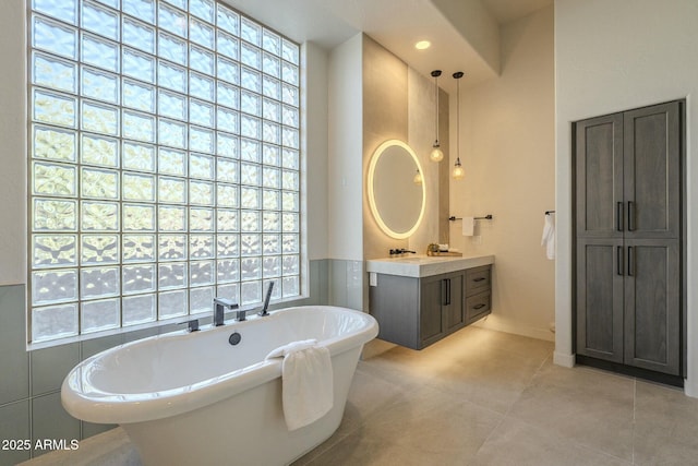 bathroom featuring vanity, a wealth of natural light, and a tub