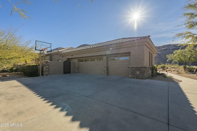 view of side of home with a garage and a mountain view