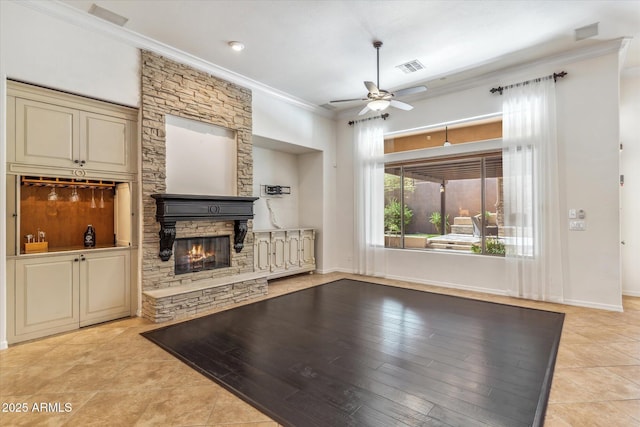 unfurnished living room with visible vents, a stone fireplace, crown molding, light tile patterned floors, and ceiling fan