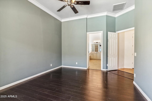 unfurnished bedroom featuring visible vents, baseboards, wood finished floors, and crown molding