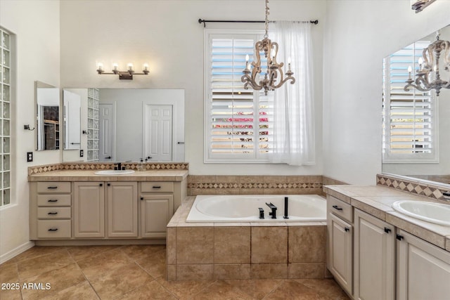 bathroom featuring plenty of natural light, an inviting chandelier, and a sink