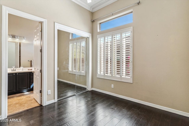 unfurnished bedroom featuring a closet, multiple windows, and wood finished floors