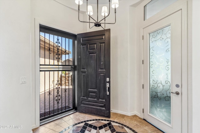 entryway with a healthy amount of sunlight, baseboards, and a chandelier