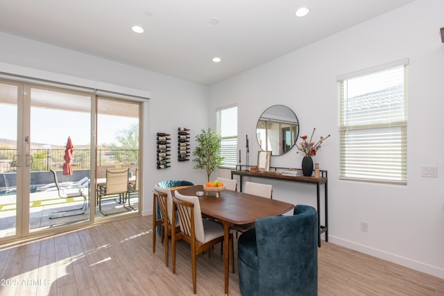 dining area featuring light wood-type flooring and a healthy amount of sunlight