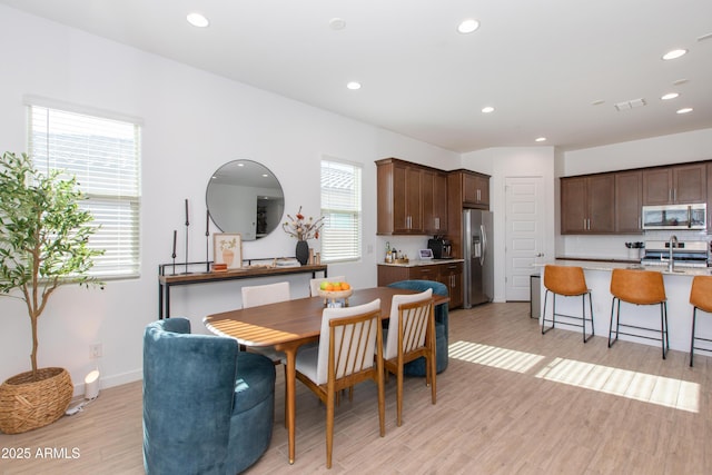 dining room featuring sink and light wood-type flooring