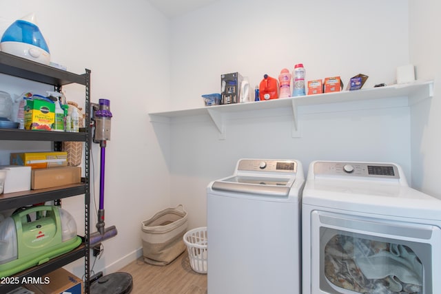 clothes washing area with light hardwood / wood-style flooring and separate washer and dryer