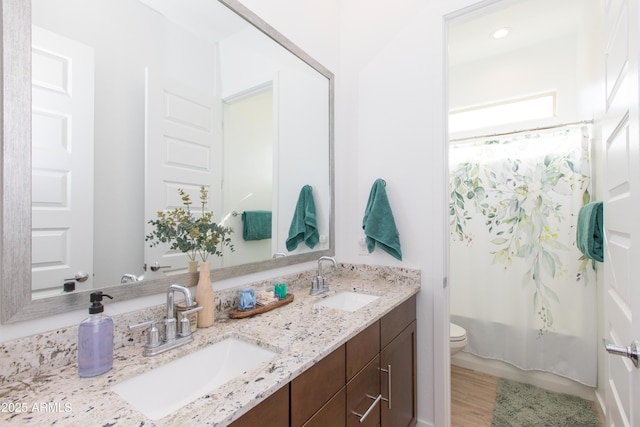 full bathroom featuring wood-type flooring, toilet, shower / bathtub combination with curtain, and vanity