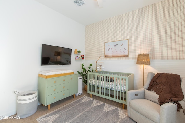 bedroom featuring ceiling fan and a nursery area