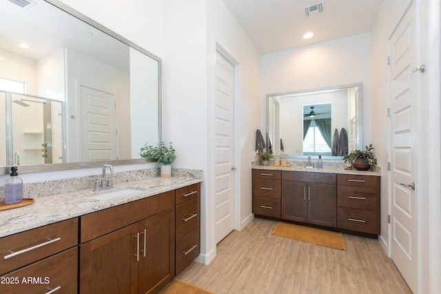 bathroom with a shower with shower door, wood-type flooring, and vanity