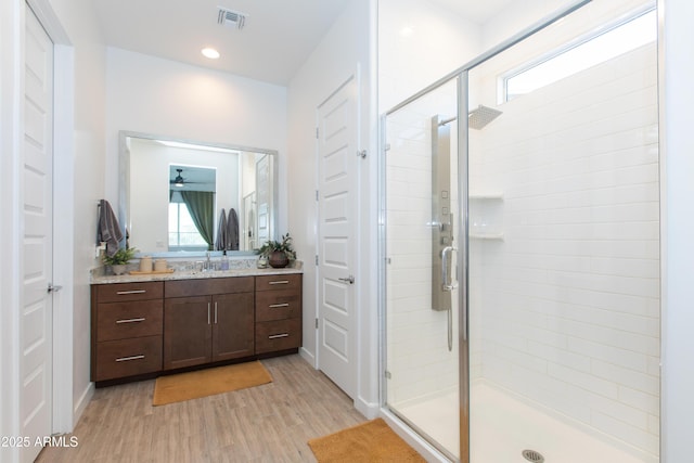 bathroom featuring wood-type flooring, walk in shower, and vanity