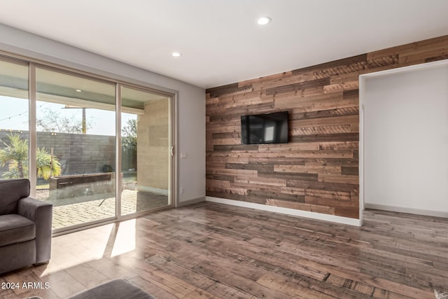 living room featuring hardwood / wood-style flooring and wood walls