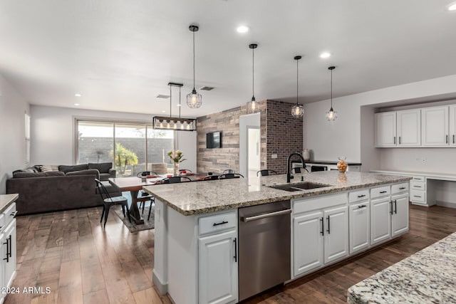 kitchen with stainless steel dishwasher, sink, pendant lighting, a center island with sink, and white cabinetry