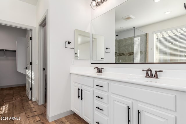 bathroom with hardwood / wood-style floors, vanity, and an enclosed shower