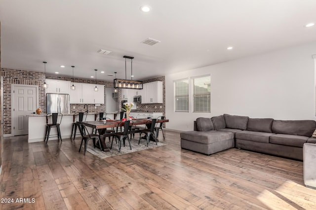 dining space featuring light hardwood / wood-style flooring and brick wall