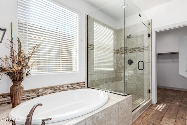 bathroom featuring plus walk in shower and hardwood / wood-style floors