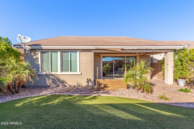 rear view of property with a lawn