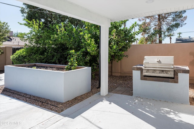 view of patio / terrace featuring exterior kitchen, a grill, and fence