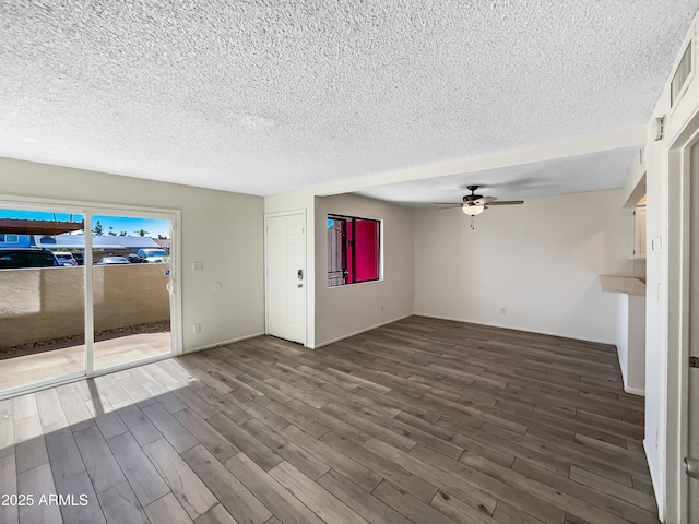 unfurnished living room featuring ceiling fan, visible vents, a textured ceiling, and wood finished floors