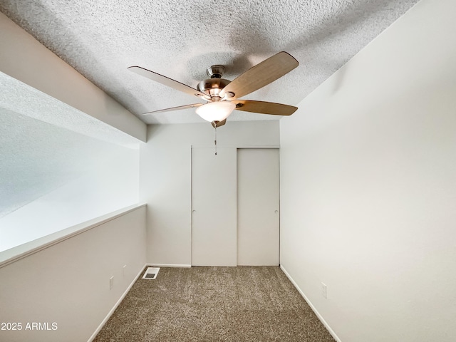 interior space with visible vents, ceiling fan, a textured ceiling, and baseboards