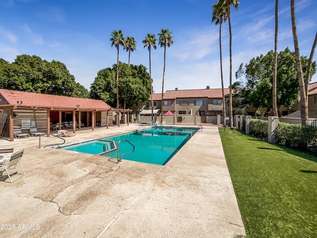 community pool with fence, a lawn, and a patio area