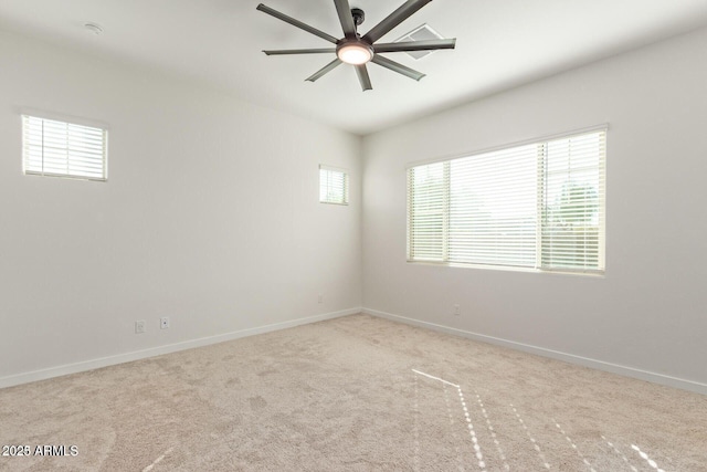 carpeted spare room featuring ceiling fan and baseboards