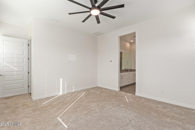 empty room featuring light carpet, visible vents, and baseboards