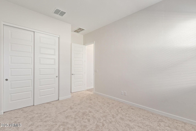 unfurnished bedroom featuring a closet, carpet flooring, visible vents, and baseboards