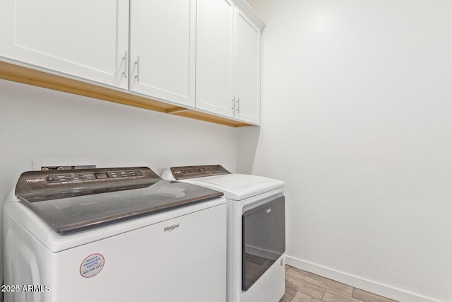 laundry room featuring light wood-style floors, cabinet space, washer and clothes dryer, and baseboards